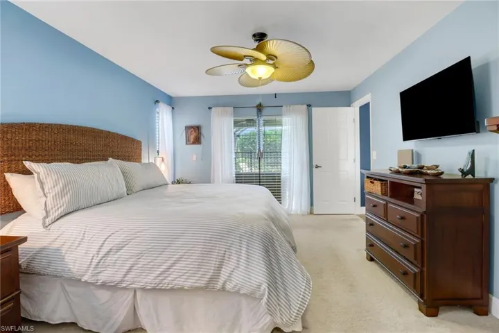 Bedroom with ceiling fan, access to outside, and light colored carpet