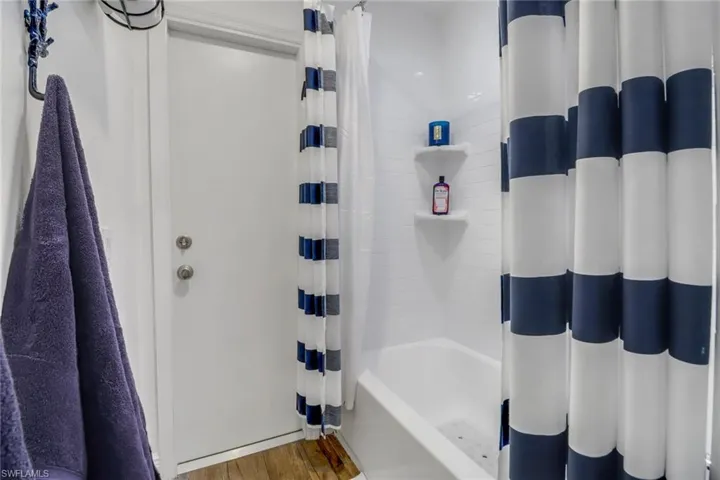 Bathroom featuring shower / bath combo with shower curtain and hardwood / wood-style floors