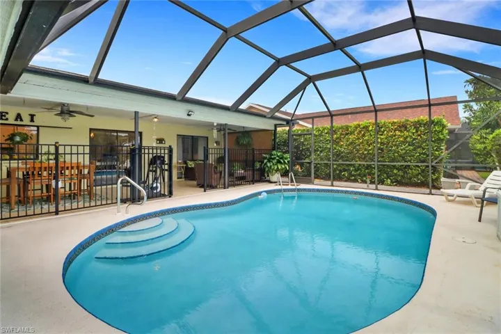 View of pool with ceiling fan, a patio, and glass enclosure