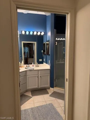 Bathroom featuring vanity, a stall shower, and light tile patterned floors