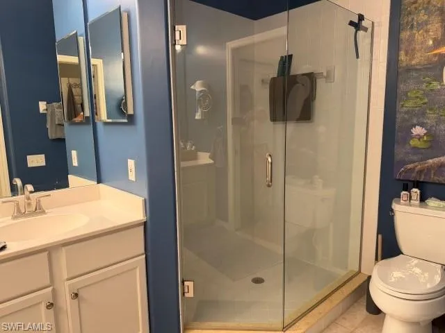 Bathroom featuring vanity, a shower stall, and tile patterned floors