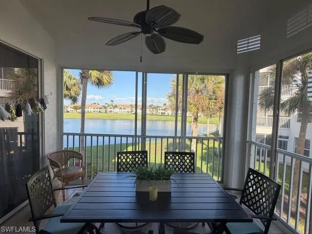 Sunroom with a textured wall, a water view, and healthy amount of natural light