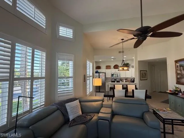 Living room with ceiling fan and a high ceiling