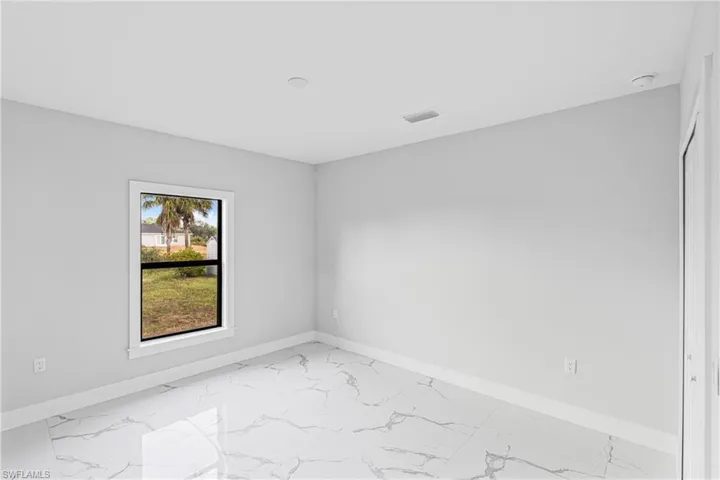 Unfurnished room with light marble finish floors and baseboards