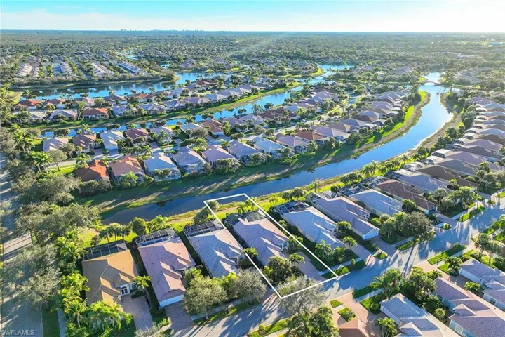 Aerial perspective of suburban area featuring property parcel outlined and a nearby body of water