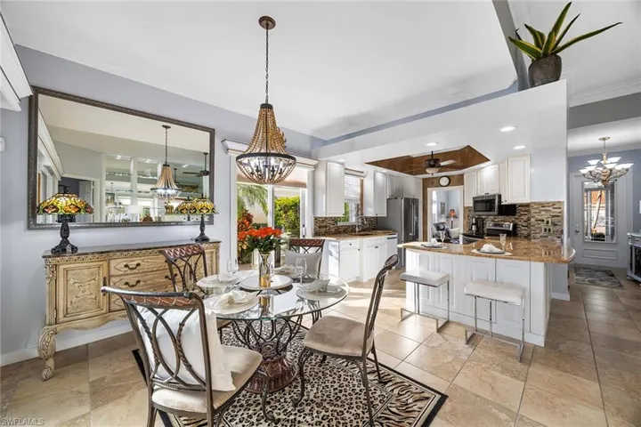 Dining room with a chandelier, ornamental molding, and recessed lighting