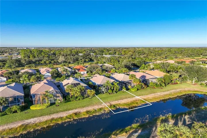 Aerial view of residential area with a large body of water and property parcel outlined