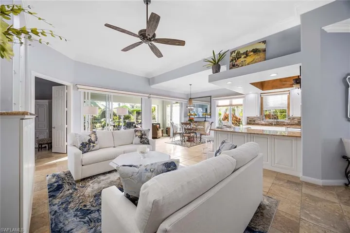 Living room featuring ceiling fan, crown molding, and plenty of natural light