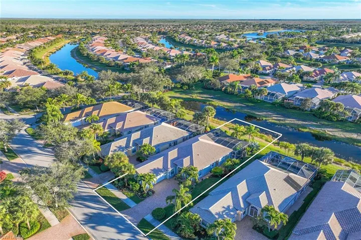 Aerial perspective of suburban area with a nearby body of water and property boundaries highlighted
