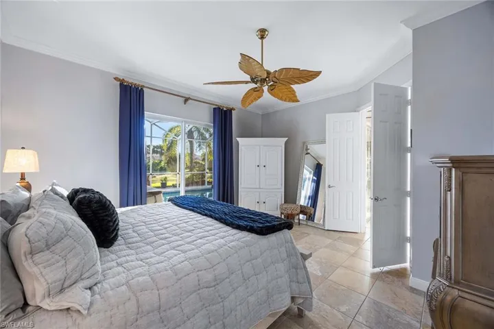 Bedroom featuring ornamental molding, access to exterior, and a ceiling fan