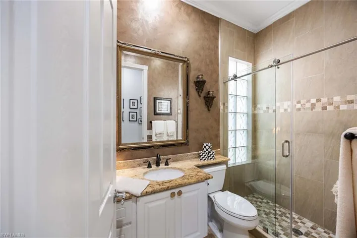 Full bathroom with vanity, ornamental molding, and a shower stall