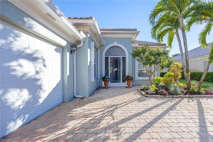 Entrance to property featuring a tile roof, stucco siding, and driveway