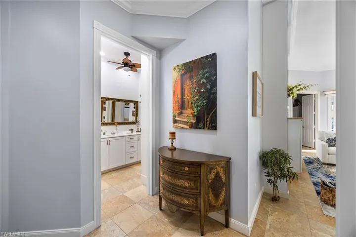 Hall featuring ornamental molding and stone tile floors