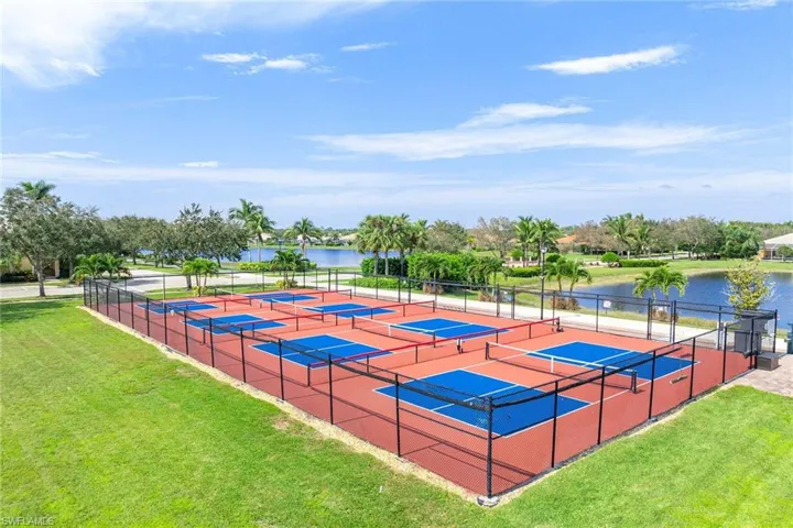 View of tennis court with a water view