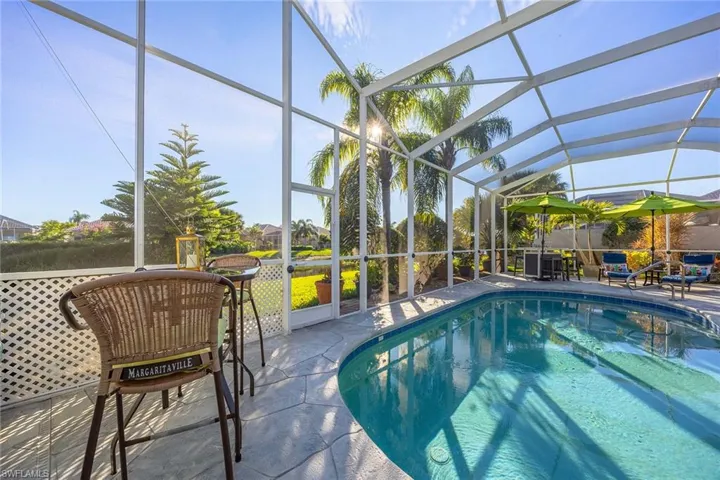 Swimming pool featuring glass enclosure, a sunroom, and a patio area