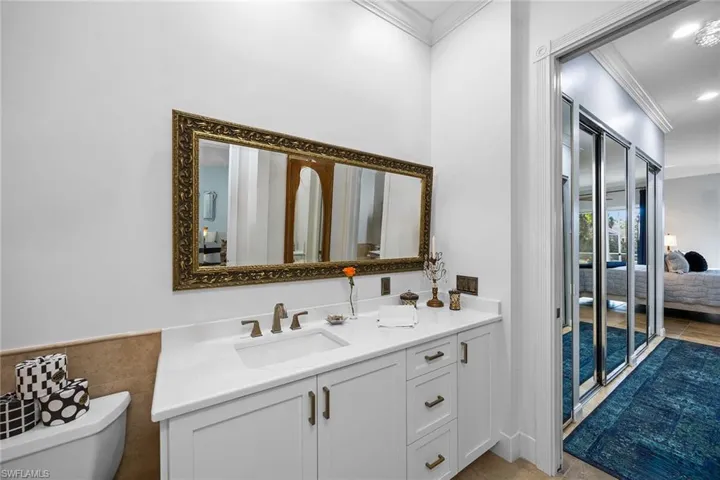 Bathroom featuring ornamental molding, vanity, and recessed lighting