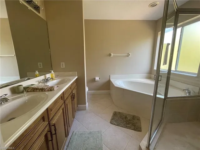 Full bathroom featuring tile patterned flooring, vanity, toilet, and independent shower and bath