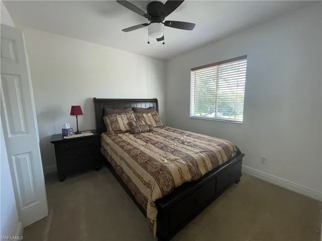 Carpeted bedroom featuring ceiling fan