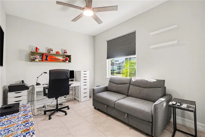 Home office / Den with a ceiling fan and light tile patterned flooring