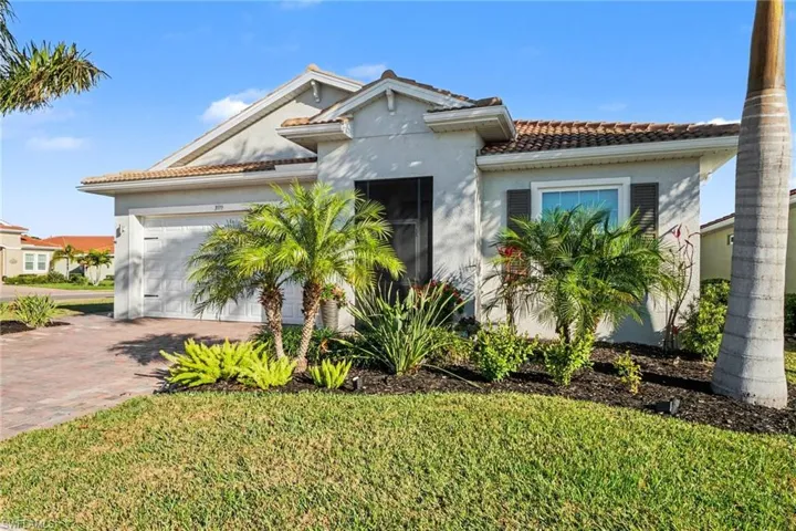 Ranch style home featuring a tile roof, decorative driveway, an attached 2.5 car garage, stucco exterior finish and a mature front lawn