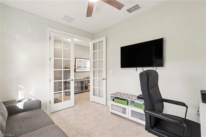 Office area featuring french doors, ceiling fan, and light tile patterned flooring