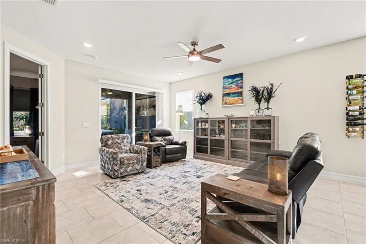 Living room featuring a ceiling fan, light tile patterned floors, and recessed lighting
