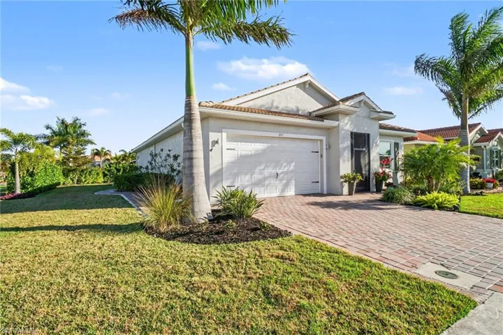 Ranch-style home featuring a front yard, stucco exterior finish, paver driveway, and an attached 2.5 car garage