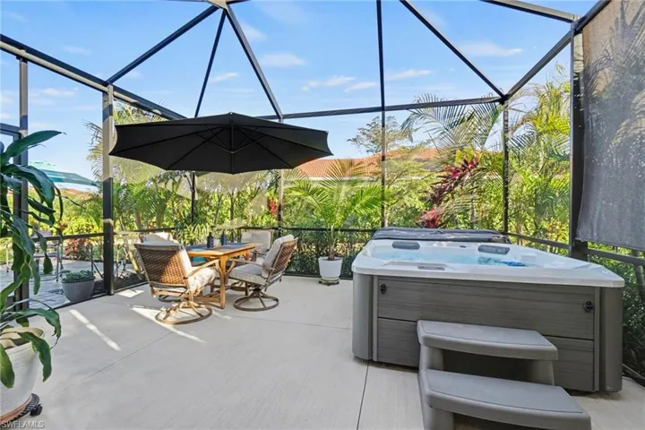 View of patio with a lanai, a hot tub, and outdoor patio