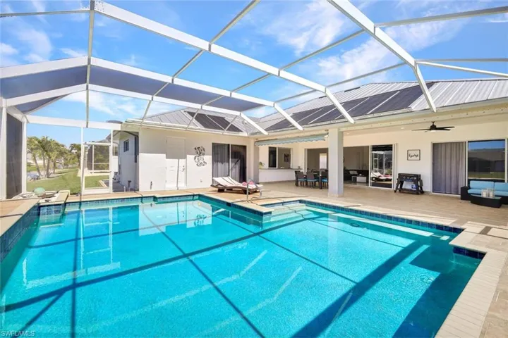Pool featuring glass enclosure, ceiling fan, and a patio area