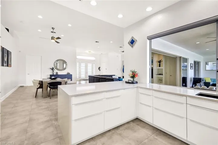 Kitchen featuring open floor plan, modern cabinets, light countertops, and a ceiling fan