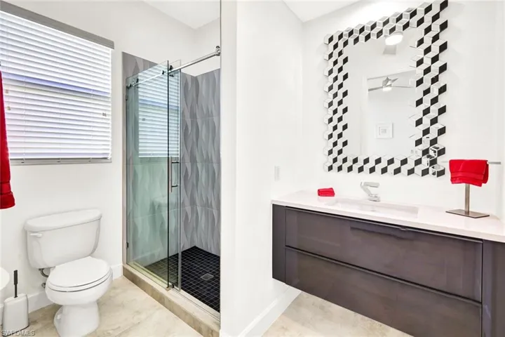 Bathroom featuring tile patterned floors, a shower stall, toilet, and vanity