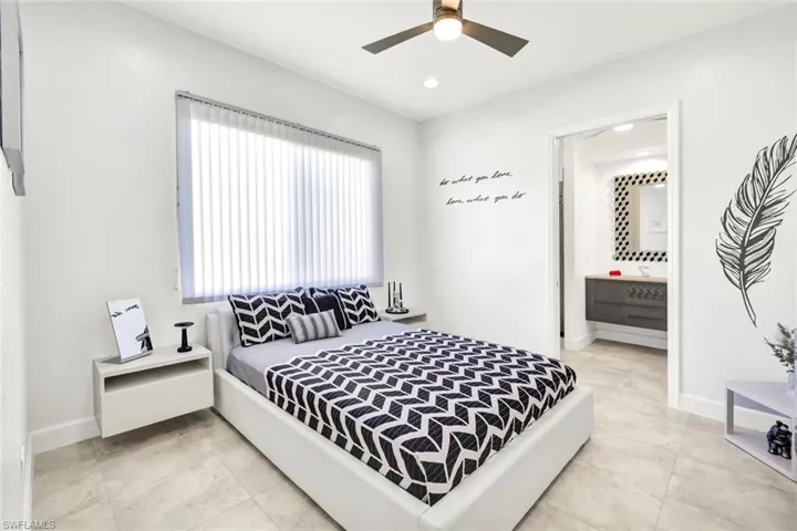 Bedroom with ensuite bath, light tile patterned floors, recessed lighting, and baseboards