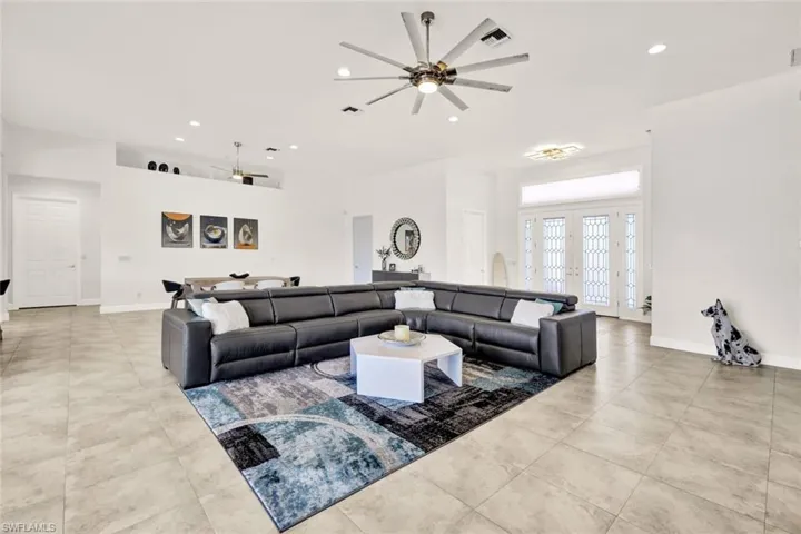 Tiled living room featuring ceiling fan, recessed lighting, visible vents, and baseboards