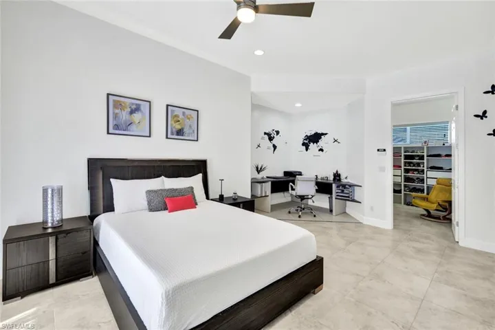 Bedroom with a spacious closet, recessed lighting, ceiling fan, and baseboards