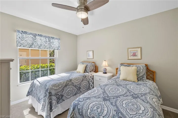 Bedroom with ceiling fan, privacy blinds and light carpet