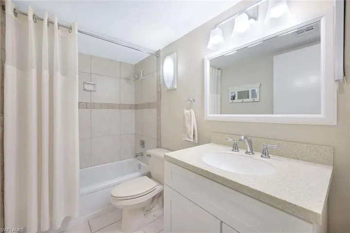 Full bathroom with vanity, toilet, tile patterned floors, and shower / bath combo