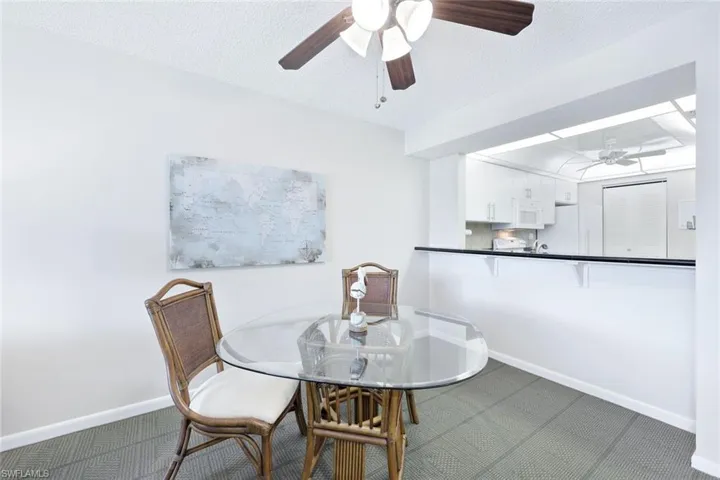 Tiled dining room with a textured ceiling and ceiling fan