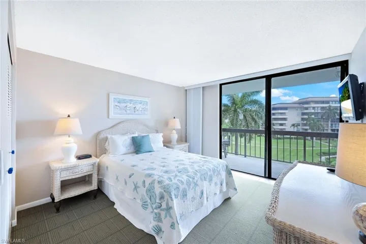 Bedroom with access to outside, a textured ceiling, and a wall of windows