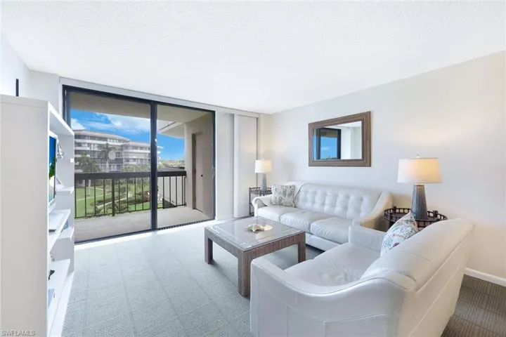 Living room featuring carpet floors, a textured ceiling, and expansive windows