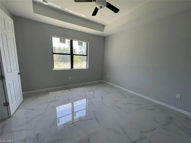 Primary Bedroom featuring a tray ceiling and ceiling fan
