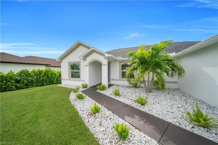 Single story home featuring a front yard, stucco siding, and roof with shingles