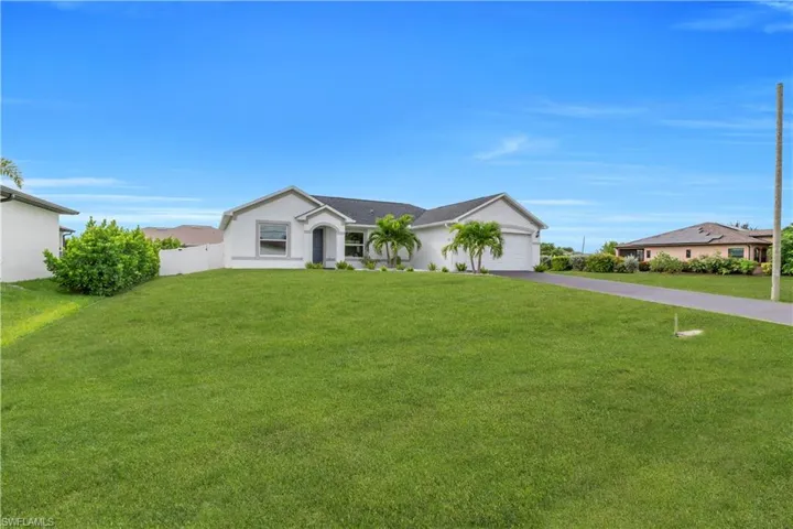 Ranch-style home with driveway, an attached garage, and stucco siding