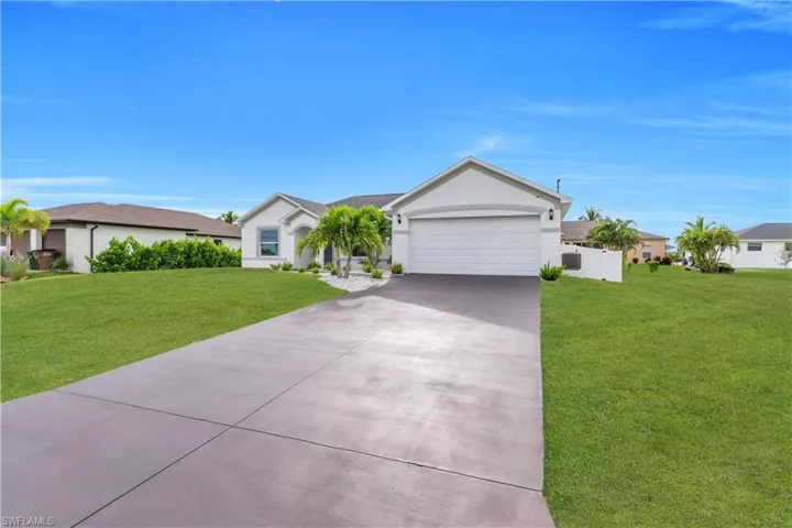 Ranch-style home featuring concrete driveway, stucco siding, and an attached garage