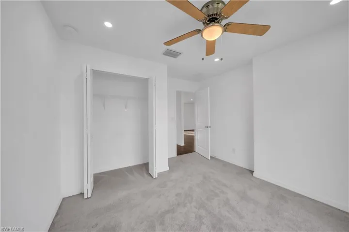 Unfurnished bedroom with recessed lighting, light colored carpet, ceiling fan, and a closet