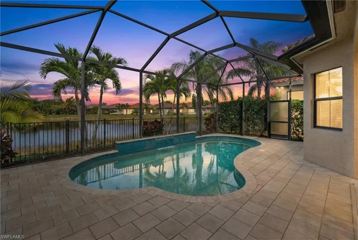 View of swimming pool featuring a sunroom, patio surround, a lanai, and a fenced backyard