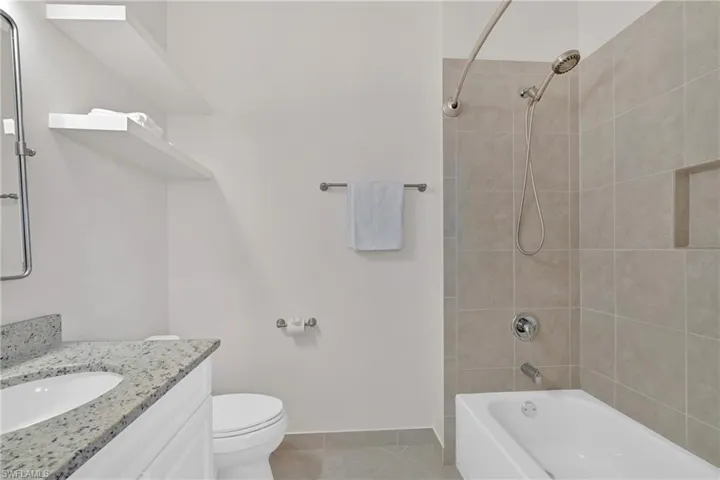 Bathroom with vanity, light tile patterned floors, and tub / shower combination