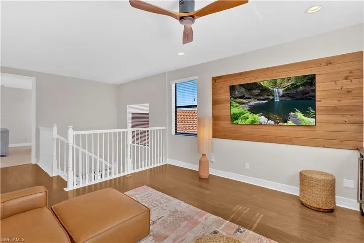 Sitting room featuring wood finished floors, a ceiling fan, an upstairs landing, and recessed lighting