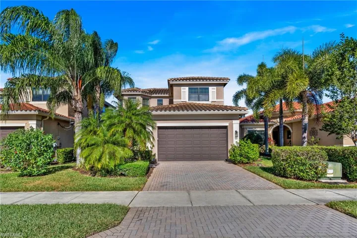 Mediterranean / spanish house featuring decorative driveway, stucco siding, a tiled roof, and a front lawn