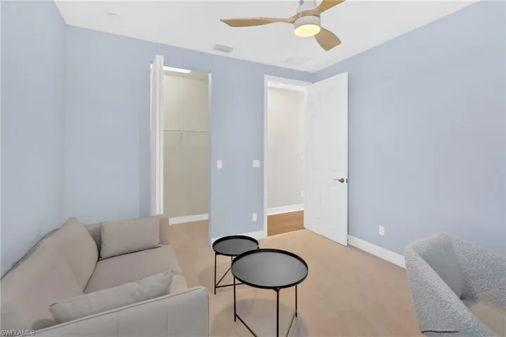 Living area featuring ceiling fan and light colored carpet
