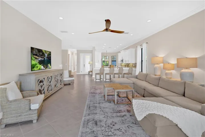 Living area featuring crown molding, recessed lighting, ceiling fan, and light tile patterned flooring
